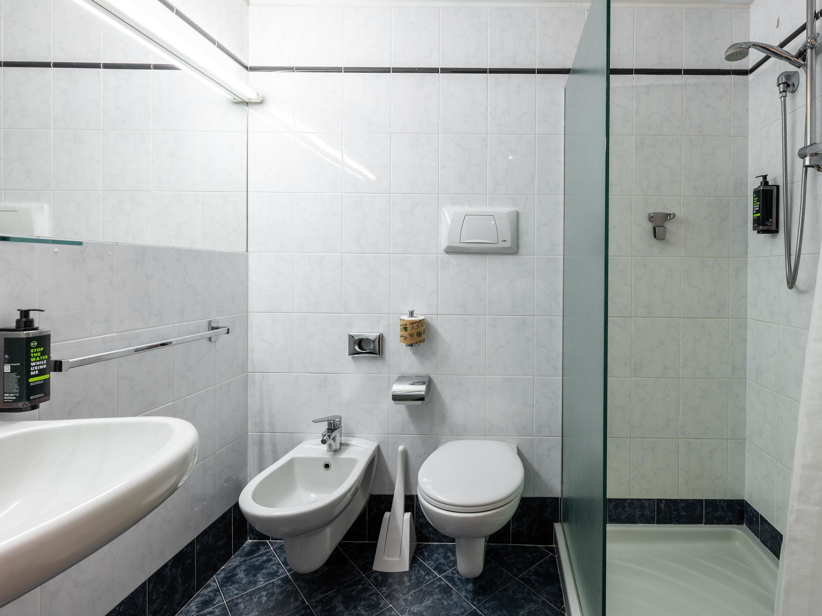 Ein modernes Badezimmer mit integriertem Bidet, Toilette und einer Duschkabine.