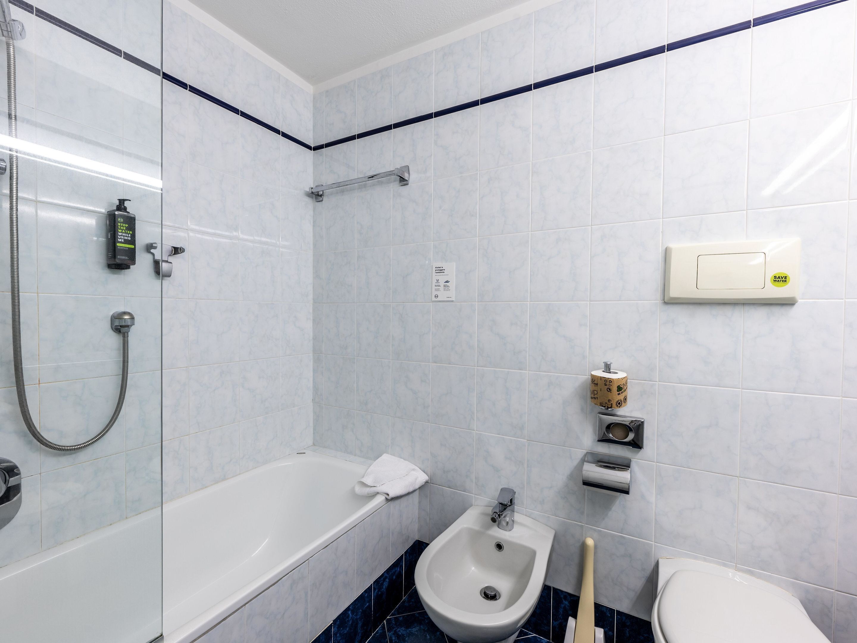 Une salle de bain équipée d’une baignoire, d’une douche, d’un bidet, de toilettes et d’un porte-serviettes.