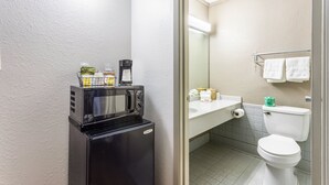 A compact bathroom with a microwave, sink, and toilet. - Red Roof Inn Meridian (Meridian)