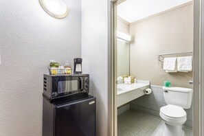 Un baño pequeño equipado con microondas, lavamanos e inodoro.