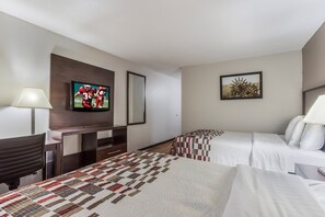 A hotel room with two beds, a TV, a desk, and a mirror. - Red Roof Inn Meridian (Meridian)