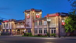 A hotel with a stone facade, multiple windows, and a sign indicating it is a Best Western hotel. - Best Western Plus Weston Inn (Logan)
