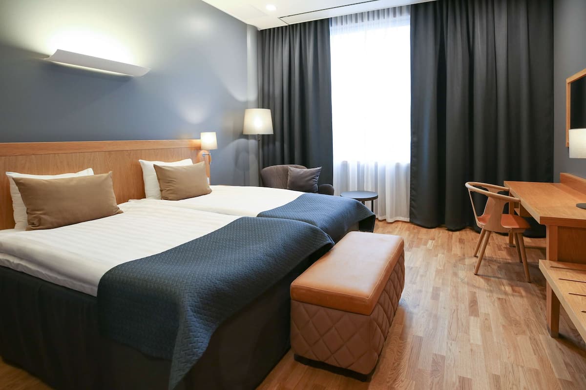 Ein Hotelzimmer mit einem großen Bett, einem Schreibtisch und einem Stuhl.