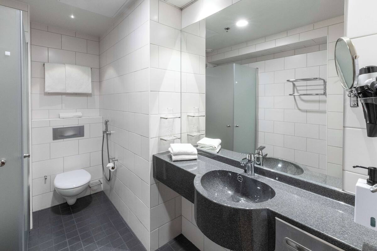 Ein modernes Badezimmer mit Toilette, Waschbecken und Spiegel.