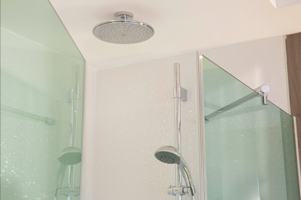A modern bathroom with a glass shower enclosure, a handheld showerhead, and a vertical rain showerhead. - Oceania Clermont-Ferrand (Clermont-Ferrand)