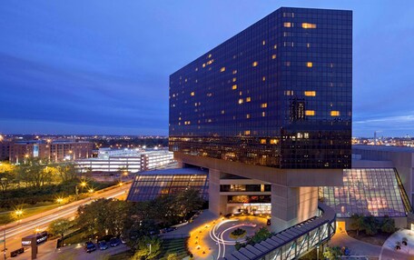 A modern building with a unique cantilevered design, featuring a glass facade and multiple levels.
