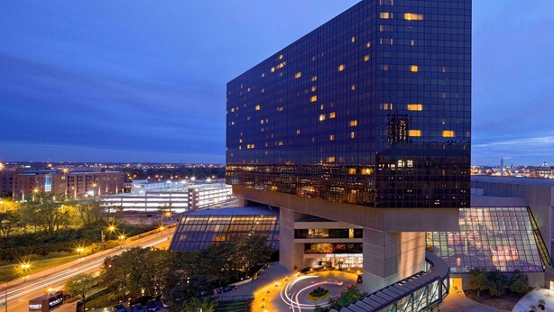A modern building with a unique cantilevered design, featuring a glass facade and multiple levels.