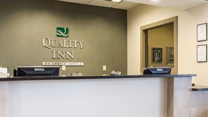 A reception desk at Quality Inn with a logo, name, and "By Choice Hotels" branding. - Quality Inn Geneseo (Geneseo)