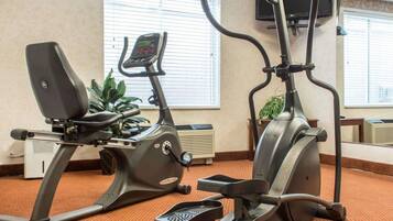 Een fitnessruimte met twee trainingsfietsen en een loopband.