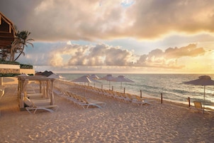 On the beach, white sand, beach cabanas, sun loungers