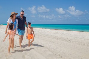 On the beach, white sand, beach cabanas, sun loungers