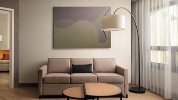 A modern living room with a beige sofa, a round coffee table, and a floor lamp.