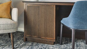 A room with a wooden desk, a blue chair, a patterned armchair, and a small table with a lamp. - London Marriott Hotel Marble Arch (London)