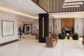 A modern lobby with a fireplace, seating area, and a large artwork on the wall. - London Marriott Hotel Marble Arch (London)