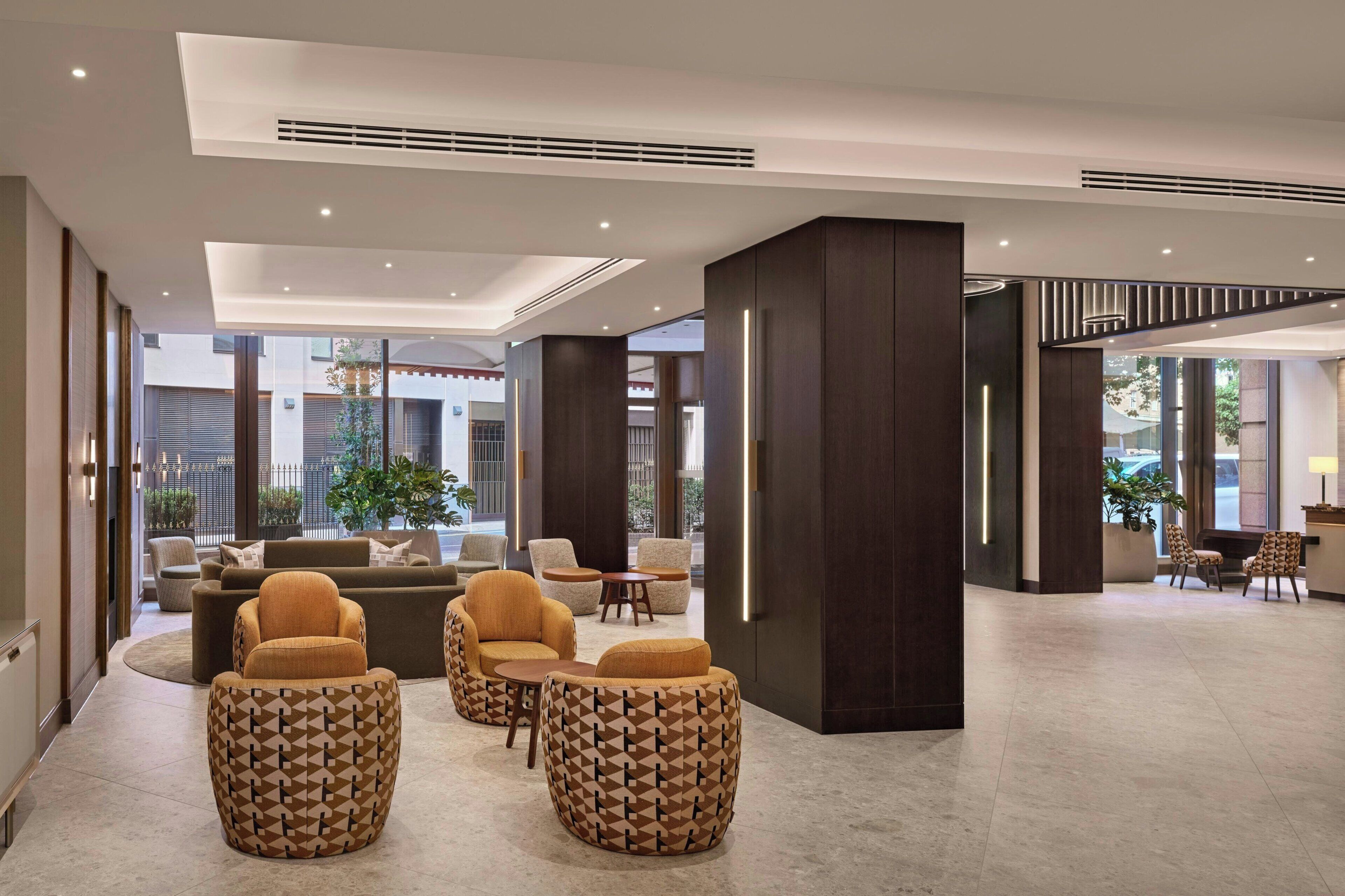 A spacious lobby with a seating area, large windows, and a reception desk.