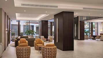 A spacious lobby with a seating area, large windows, and a reception desk.