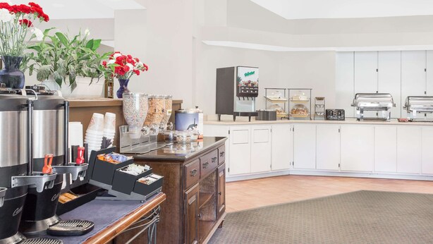 A modern kitchen with a coffee station, a refrigerator, and a microwave.