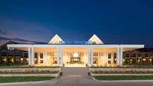 A modern hotel with a covered entrance, a prominent sign, and a well-lit facade. - Hotel Renovo Des Moines Urbandale,Tapestry Collection Hilton (Urbandale)