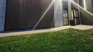 A modern building with a large garage door, a brick wall, and a glass entrance. - Comfort Inn Guelph (Guelph)