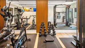 A modern gym with cardio machines, free weights, and a mirrored wall. - Comfort Inn Guelph (Guelph)