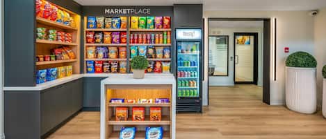 A modern marketplace with shelves of snacks and a refrigerated section.