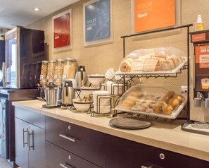 Um buffet de café da manhã com diversas opções de comida e máquinas de café.