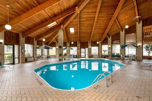 Una piscina techada, sillones reclinables de piscina