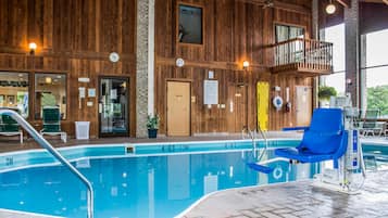 Piscina interna com paredes de madeira, uma cadeira azul e um posto de salva-vidas.