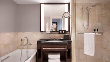 A modern bathroom with a bathtub, a sink, a mirror, and a shower.