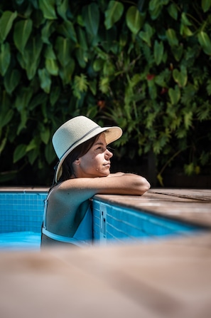 Una piscina al aire libre, camas de piscina gratis, sombrillas