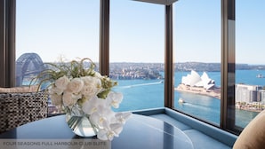 Quarto com uma janela grande que oferece vista para a Casa de Ópera de Sydney e a Ponte Harbour.