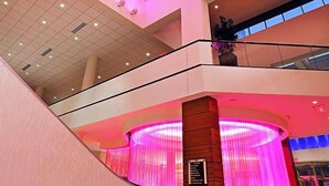 A multi-level atrium with a central staircase, a skylight, and a reception area with a curved design. - Radisson Plaza Hotel at Kalamazoo Center (Kalamazoo)