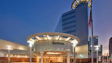 The Radisson Plaza Hotel & Suites with a modern design, featuring a circular entrance canopy and a tall building with a circular top.