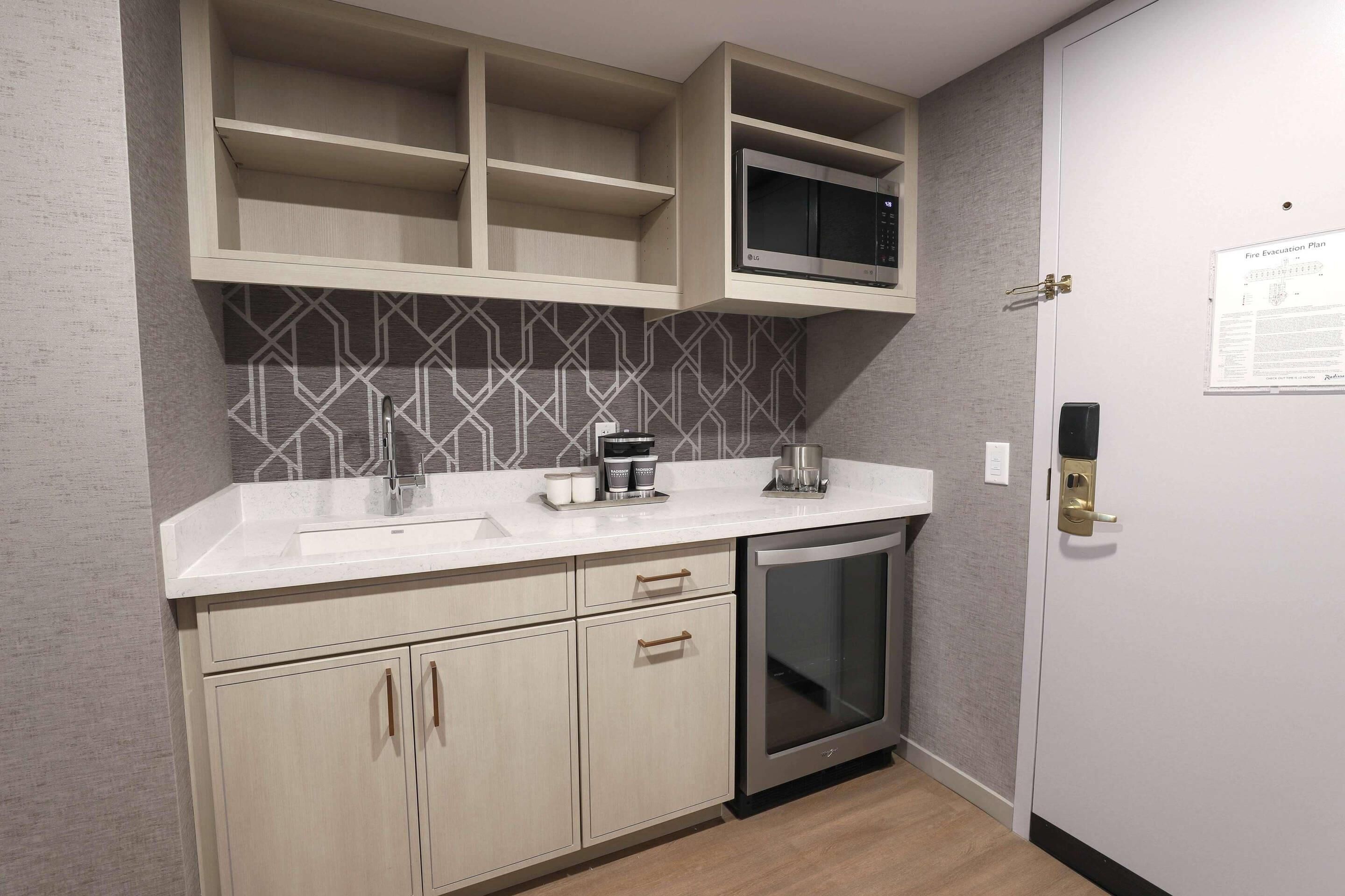 A modern kitchen with a built-in microwave, a coffee machine, and a dishwasher.