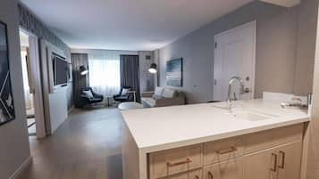 Une cuisine moderne dotée d’un grand îlot central, de meubles de rangement intégrés et d’un évier à deux bacs.