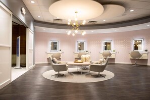 A modern interior with a circular seating area, recessed ceiling lights, and a large chandelier. - Radisson Plaza Hotel at Kalamazoo Center (Kalamazoo)