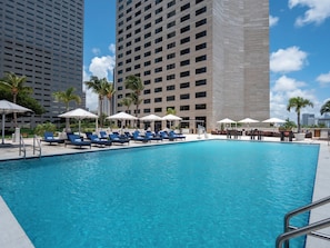 A swimming pool with lounge chairs and umbrellas, surrounded by tall buildings. - InterContinental Miami by IHG (Miami)