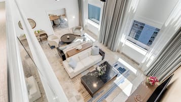 Uma sala de estar ampla, com sofá, mesa de centro e mesa de jantar.