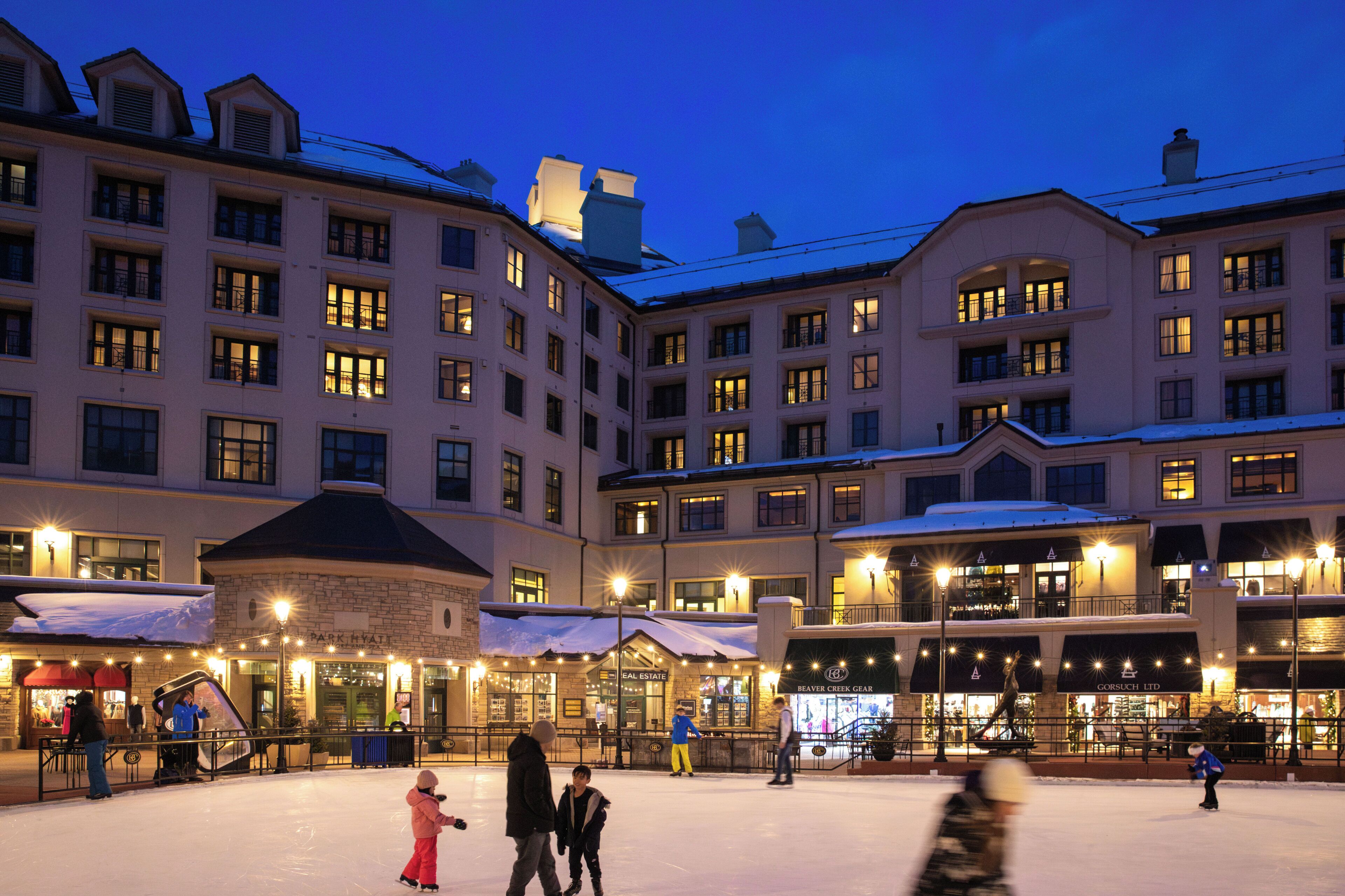 A hotel with multiple floors, outdoor ice skating area, and several ground-level shops.
