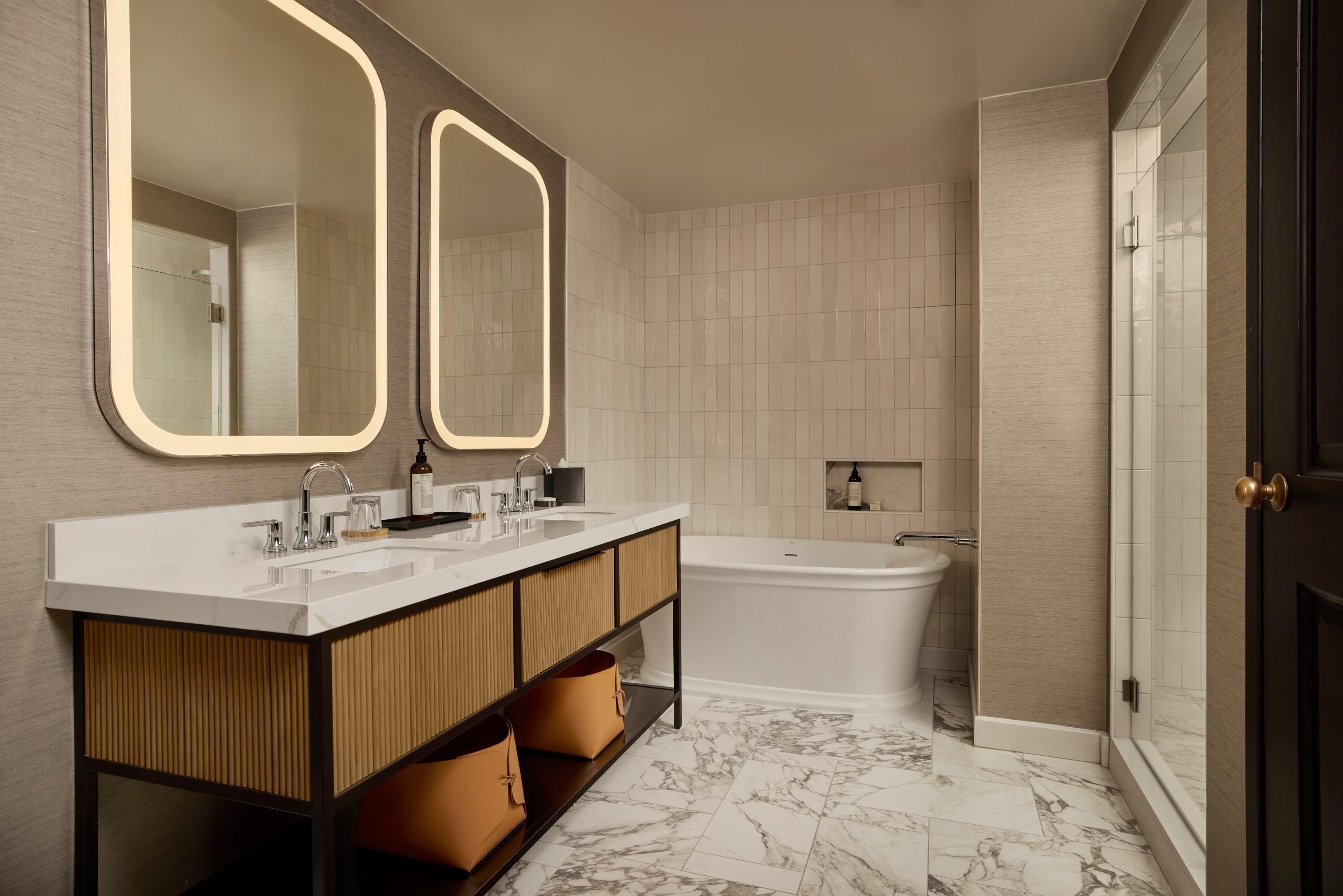 A modern bathroom with a double sink vanity, a bathtub, and a shower.