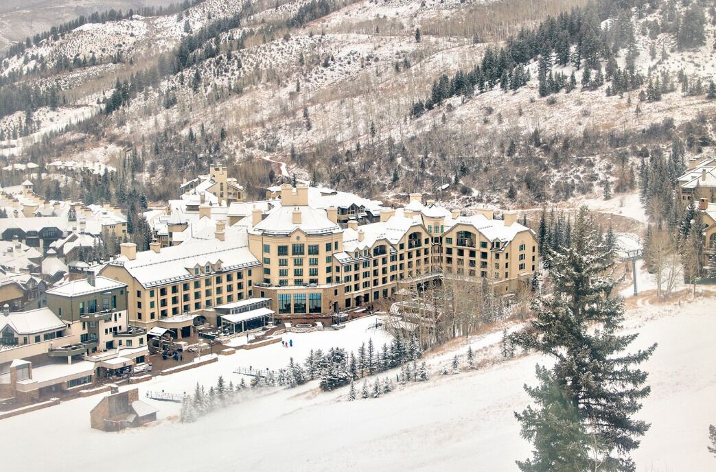 A large, multi-story hotel with a symmetrical facade, multiple chimneys, and a central courtyard.