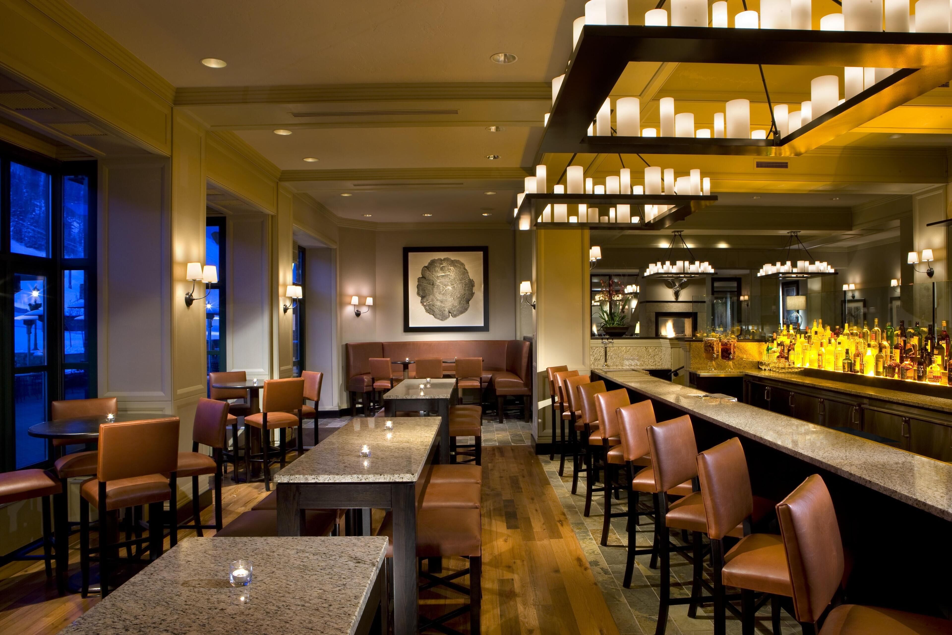 A bar area with seating, a counter with bottles, and a framed artwork on the wall.