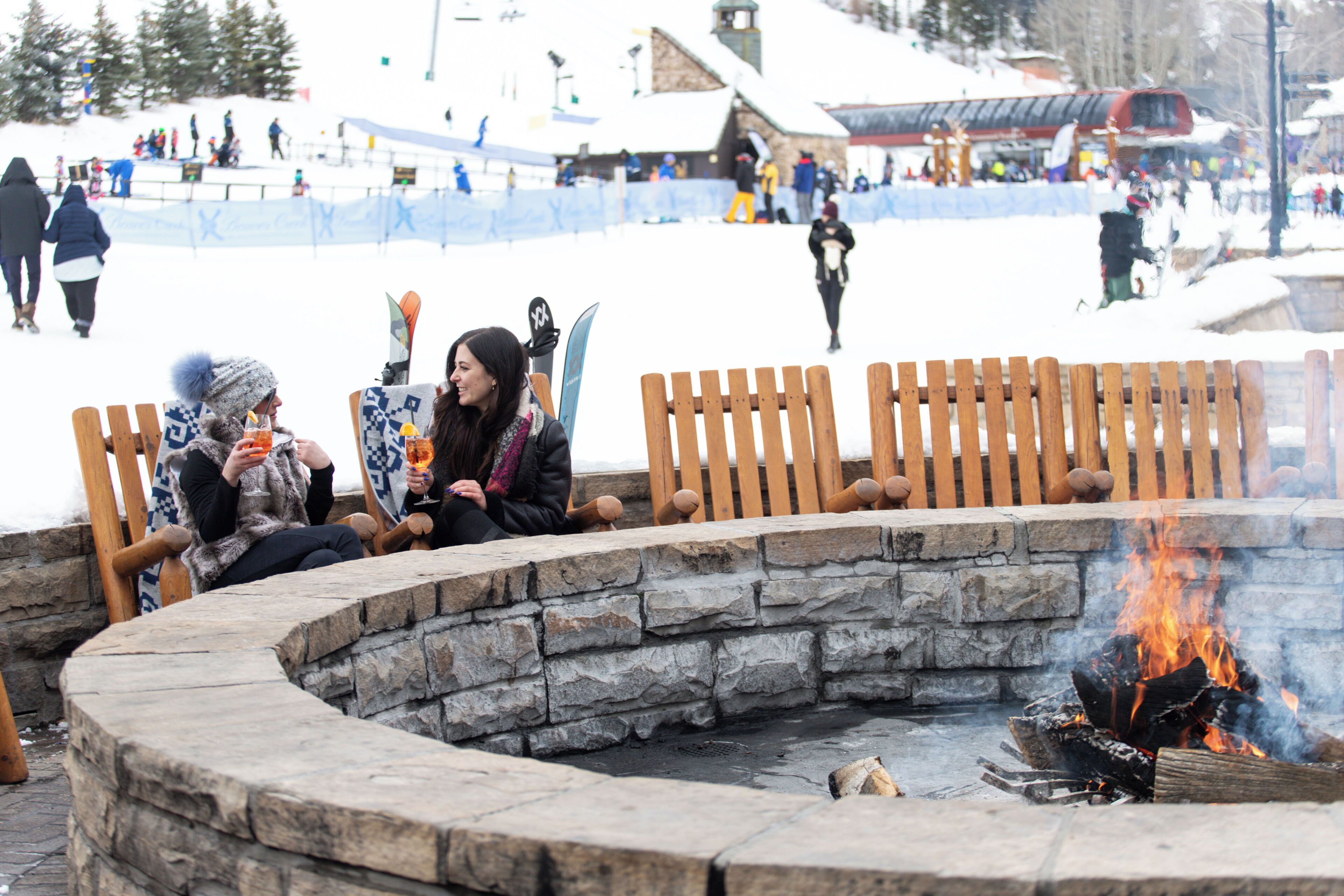A stone fire pit surrounded by wooden benches.
