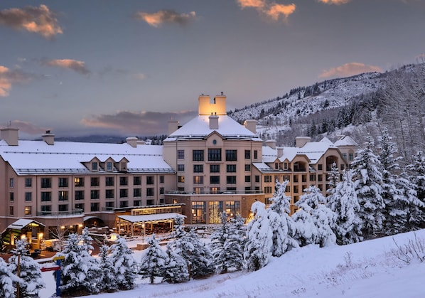 A large hotel with multiple buildings, a covered outdoor area, and snow-covered surroundings.
