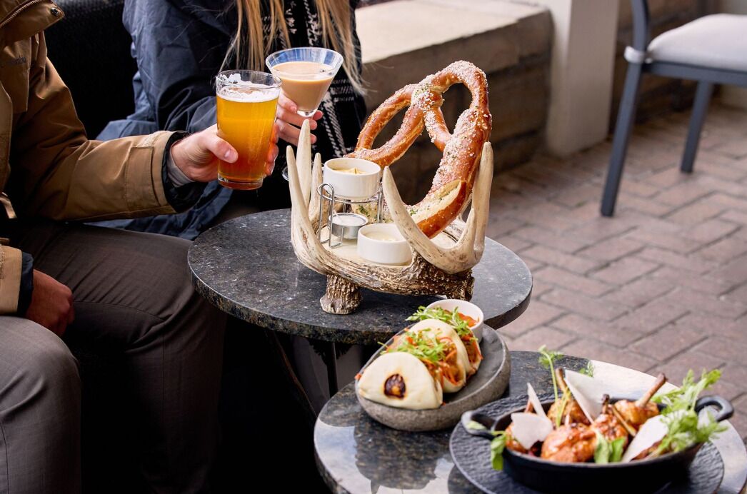 A dining table with pretzels, a martini glass, and a beer mug.