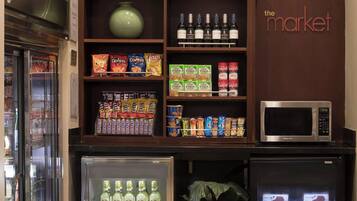 Una zona de kitchenette con microondas, refrigerador y enfriador de bebidas.