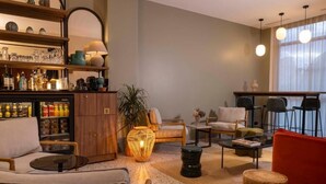 Una sala de estar moderna con área de bar, asientos cómodos y un amplio ventanal que proporciona luz natural.