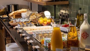 Un bufé con diferentes opciones de comida, como frutas, pasteles y bebidas.