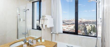 A modern bathroom with a large window, a bathtub, and a shower.