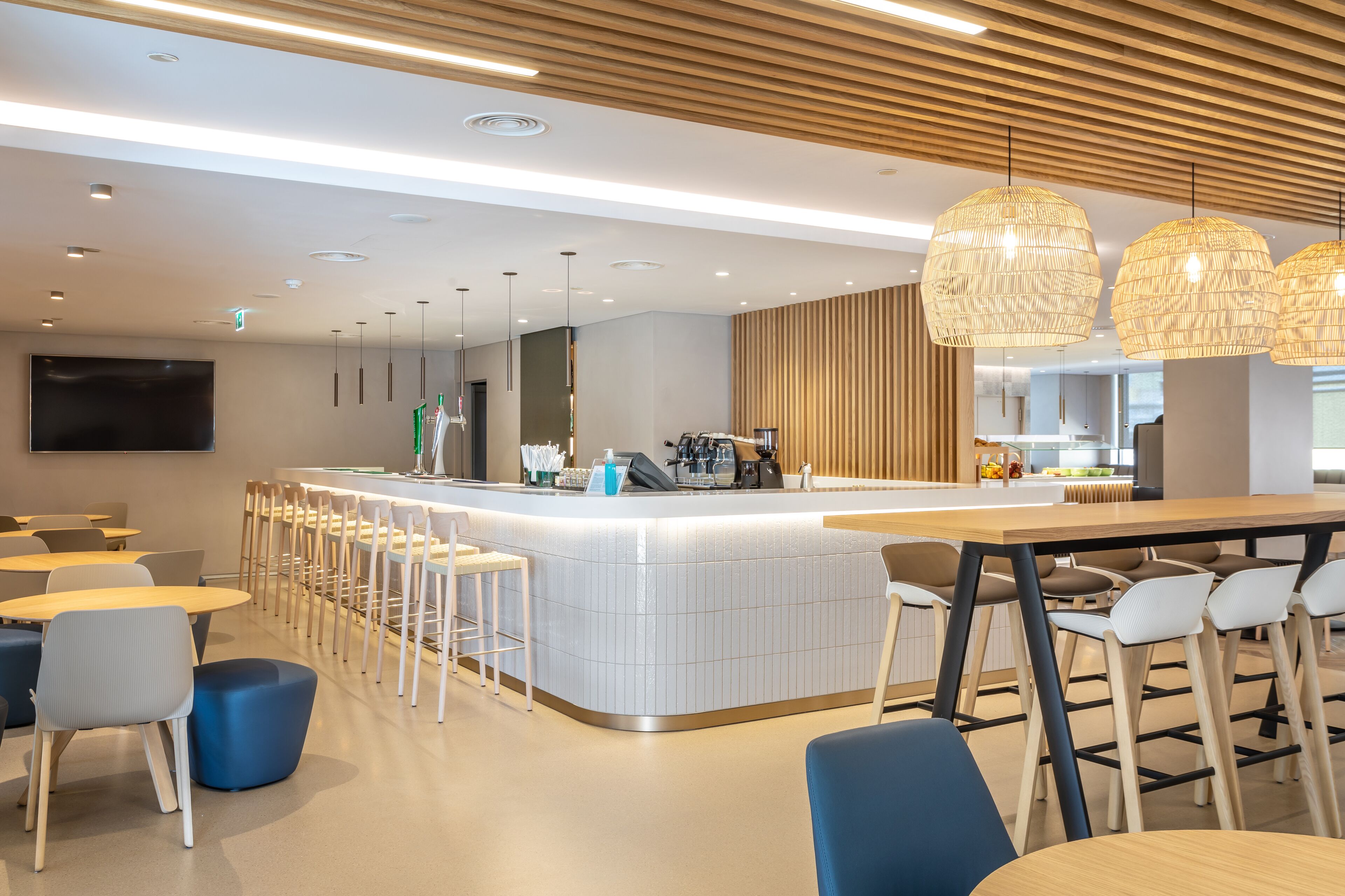 Un espace bar moderne avec un comptoir, des tabourets et des luminaires suspendus.